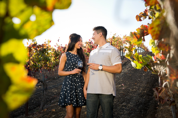 A couple enjoys a tasting in the vineyard.